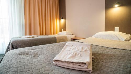 ワルシャワにあるHotel Gajaのベッド2台付きの客室で、ベッドの上にホテルサインが付いています。