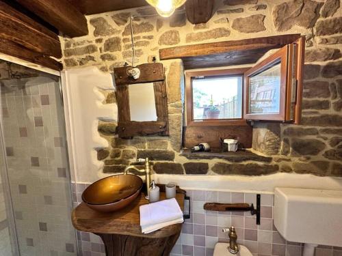 een badkamer met een wastafel en een stenen muur bij Rustico Toscano in Castel Focognano