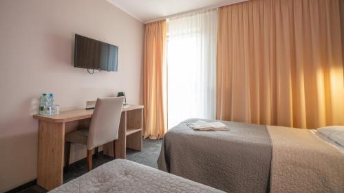 a hotel room with a desk and a bed at Hotel Gaja in Warsaw