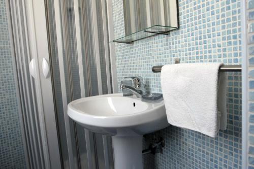 La salle de bains est pourvue d'un lavabo, d'un miroir et d'une serviette. dans l'établissement Dei Meravigli, à Bari