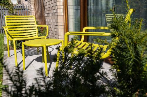 two yellow chairs sitting on a patio with plants at B85 Suites in Warsaw