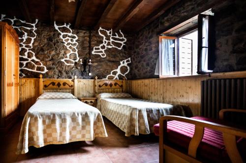 a bedroom with two beds in a room at Casa de Aldea Menéndez in Cangas del Narcea