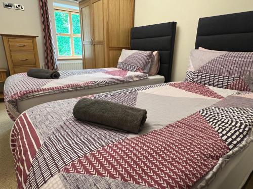 trzy łóżka siedzące obok siebie w pokoju w obiekcie 24 Castle Hume Court Holiday House w mieście Enniskillen