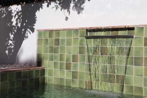 un mur carrelé vert avec une fontaine dans l'établissement Casa da Sé, à Silves