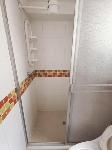 y baño con ducha y puerta de cristal. en Apartamento moderno en condominio Agualongo, en Pasto