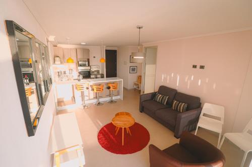 ein Wohnzimmer und eine Küche mit einem Sofa und einem Tisch in der Unterkunft ARICA SUNSET in Arica