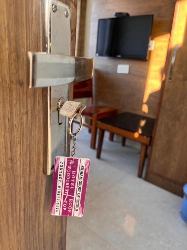 a tag hanging from a door with a key at Hotel Woodcrest Zirakpur Chandigarh- Best Family Hotel in Chandīgarh