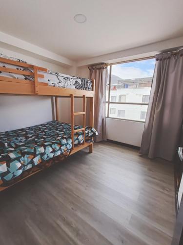 a bedroom with bunk beds and a large window at Apartamento moderno en condominio Agualongo in Pasto