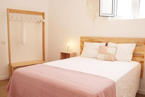 a bedroom with a white bed with a pink blanket at Casa da Sé in Silves
