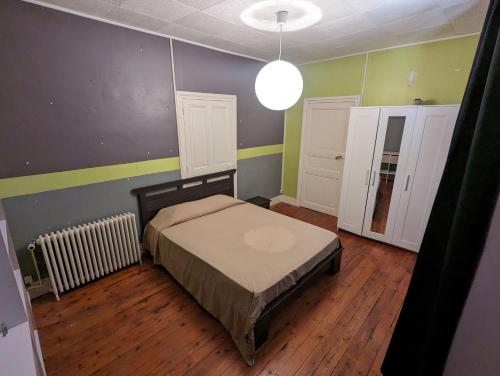 - une chambre avec un lit dans une pièce aux murs verts dans l'établissement Charme et Authenticité, à Perreux