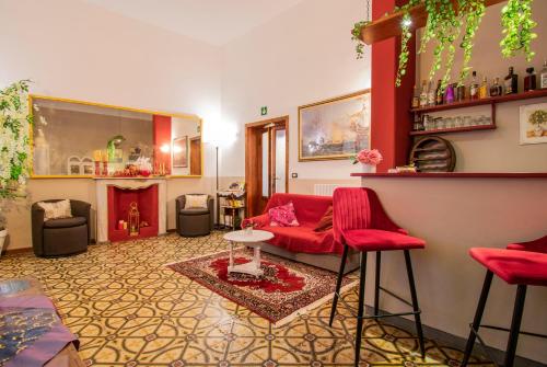 sala de estar con sillas rojas y sofá rojo en Hotel Albachiara, en Viareggio