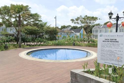 a swimming pool in a park with a sign next to it at Verse Guest House in Pontianak