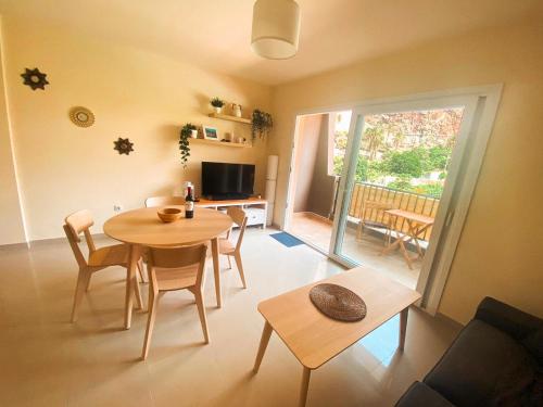 a living room with a table and chairs and a television at Playa Maria Apartment 43 (Puerta al Cielo) in La Playa Calera