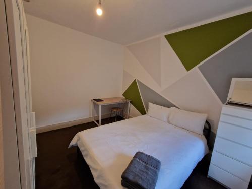 um quarto com uma cama branca com uma bolsa preta em Brewery rd Double room em Plumstead