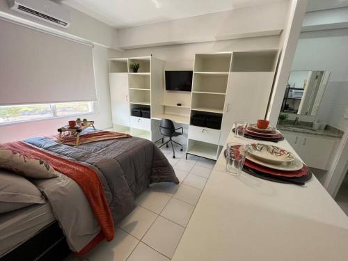 Un dormitorio con una cama y una mesa dentro. en Apartamento 133 Magnífico!, en Ribeirão Preto