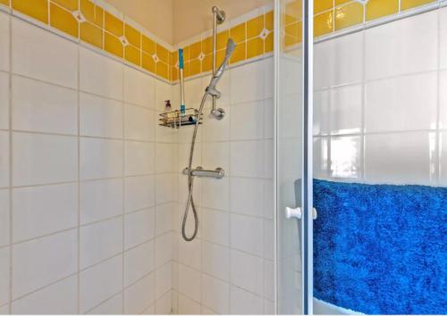 a shower with a blue shower curtain in a bathroom at Résidence route de la corniche vue mer in Plestin-les-Grèves