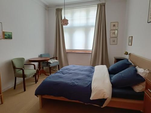 a bedroom with a bed and a table and a window at Saillant in Ieper