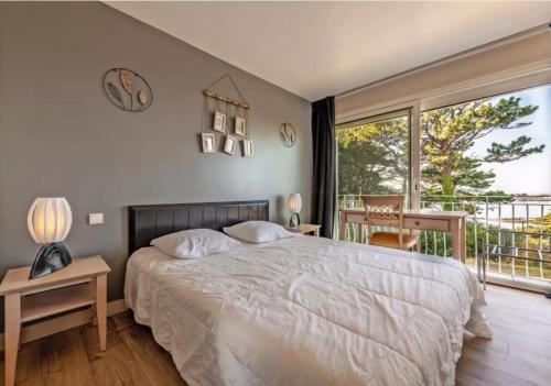 une chambre avec un grand lit et un balcon dans l'établissement Résidence route de la corniche vue mer, à Plestin-les-Grèves