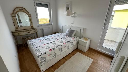 - une petite chambre avec un lit et un miroir dans l'établissement Tranquil apartment across the bridge, à Novi Sad
