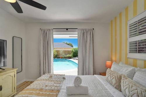 a bedroom with a bed and a pool outside a window at The Dreamcatcher - 4 Bed, 2 Bath, Private Heated Pool, BBQ, Game Room, Park in Fort Lauderdale