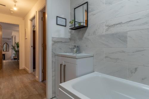uma casa de banho branca com uma banheira e um lavatório em Luxury Chapel Apartment within City Walls em Chester