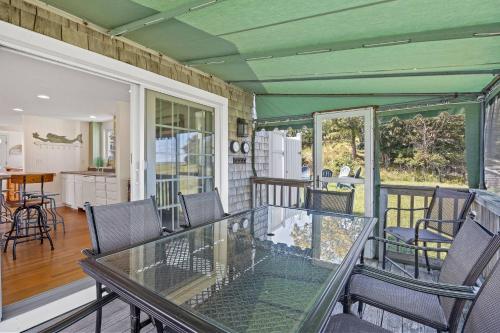 a dining room with a glass table and chairs at Sunset Sanctuary: Minot Beach Scituate in Scituate