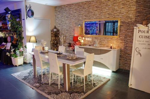 une salle à manger avec une table et des chaises blanches dans l'établissement Cottage des Deux Époques - CareHost, à Saint-Genis-de-Saintonge