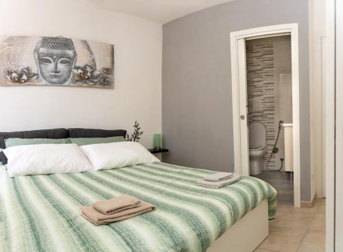 a bedroom with a bed with a green and white blanket at La Julienne AC in Naples