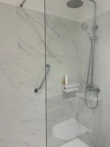 baño con ducha y puerta de cristal en Fatima`s House, en Funchal