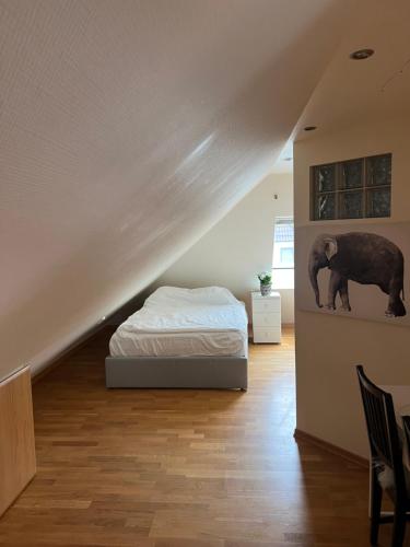 a bedroom with a bed and a painting of an elephant at Vindsvåning på Salängen in Borås