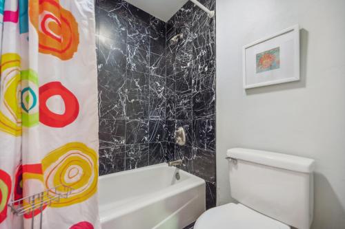 a bathroom with a black marble shower curtain and a toilet at Monarch Beach - Gated Community - 1 Bed King in Dana Point