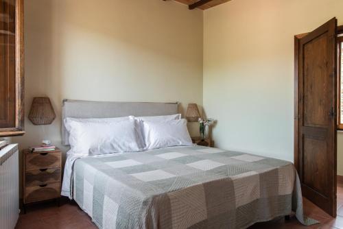 a bedroom with a bed with a checkered blanket at Il Borghetto - La Ghibellina Townhouse in Castelnuovo dellʼAbate