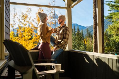a man and woman sitting on a porch looking out of a window at Johnston Canyon Lodge & Bungalows in Castle Junction