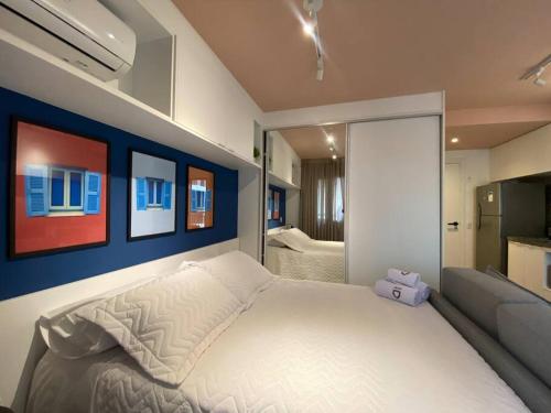 une chambre avec un lit blanc et un canapé dans l'établissement Colorful Windows - novo studio na Liberdade, à São Paulo