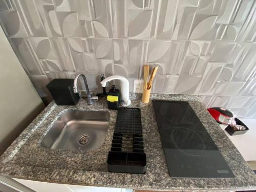 un plan de travail de cuisine avec un évier et un appareil de cuisine dans l'établissement Colorful Windows - novo studio na Liberdade, à São Paulo