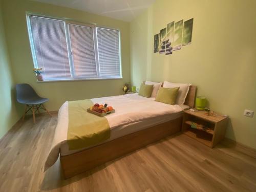 a bedroom with a bed with a tray of fruit on it at Уютен нов апартамент - Стара Загора с две спални in Stara Zagora