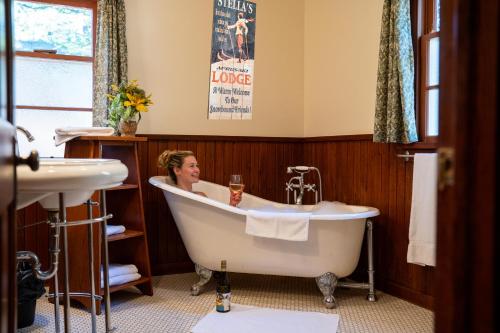 a woman sitting in a bath tub in a bathroom at Johnston Canyon Lodge & Bungalows in Castle Junction
