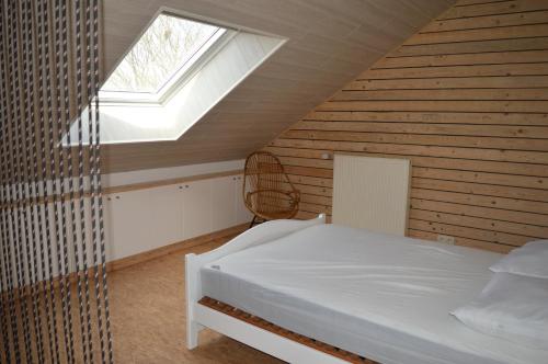 een slaapkamer met een bed en een dakraam bij Chez nous in Chiny