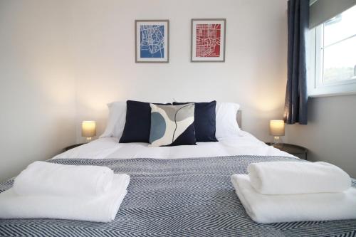 a bedroom with a bed with two pillows on it at Beautiful Modern House with Free Parking in Swansea