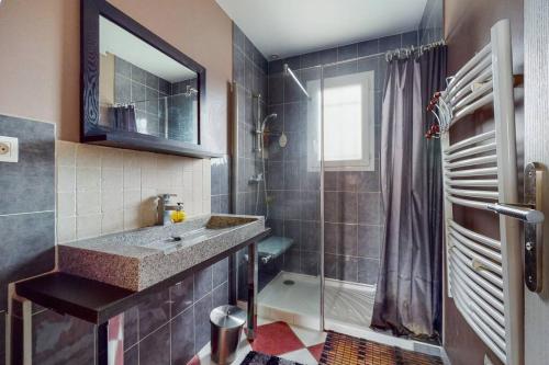 W łazience znajduje się umywalka i prysznic. w obiekcie Maison quartier résidentiel w mieście Saint-Priest