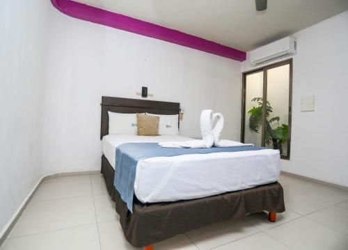Un dormitorio con una cama grande en una habitación. en Pa´Xa Mama Hotel Boutique, en Cancún