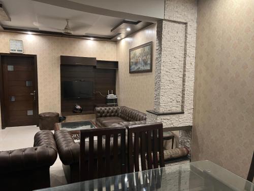 a living room with leather furniture and a flat screen tv at Royal Three Bed Room Full House Dha Phase 6 Lahore in Lahore