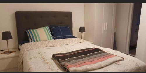 a bedroom with a bed with a blanket and pillows at B & E Apartment in Huddinge