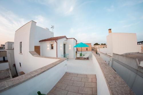 un balcone con edifici bianchi e un ombrello blu di Nonna Veronica a Gemini