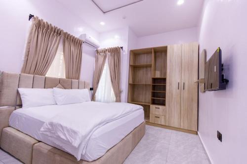 sypialnia z łóżkiem i telewizorem z płaskim ekranem w obiekcie Rhema Apartments w mieście Lagos