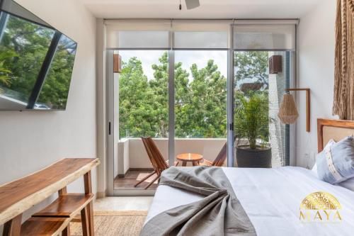 图卢姆NHOA 311B Lux 1BR Condo Pool View in Aldea Zama的一间卧室，里面有一张床和一扇大窗户。