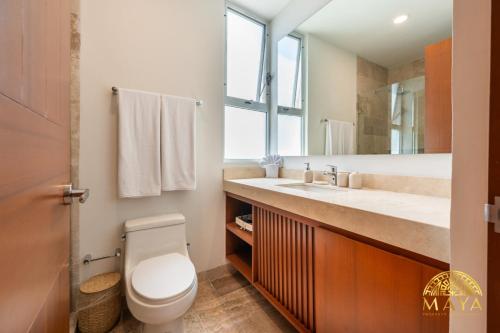 图卢姆NHOA 311B Lux 1BR Condo Pool View in Aldea Zama的浴室里有马桶、洗手池和镜子。