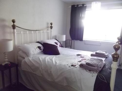 uma cama com lençóis e almofadas brancos e uma janela em Hall Dale View near Matlock & Peak District em Matlock