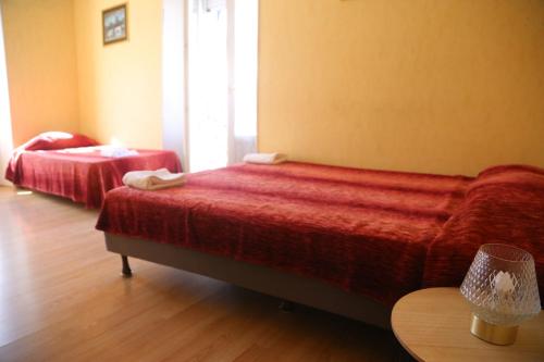 a hotel room with two beds and a table at Hôtel restaurant Le Parisien in Lourdes