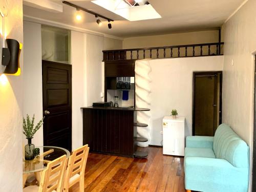 - un salon avec un canapé bleu et une table dans l'établissement Apartamentos Montes, à Cusco